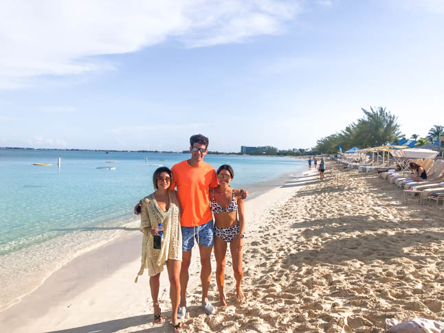 twins with boyfriend standing on seven mile beach in grand cayman islands ritz carlton