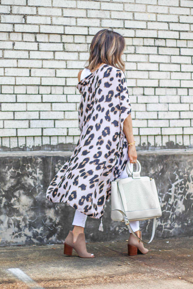 fashion blogger wearing leopard kimono with white jeans and peep toe booties and a white summer bag