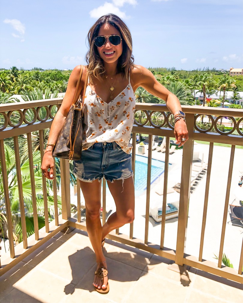 fashion blogger wearing a floral cami and ripped denim shorts 