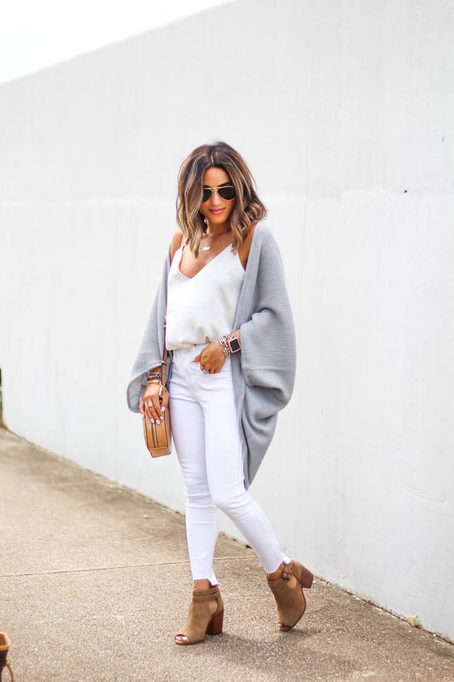 lifestyle and fashion blogger Alexis Belbel of A Double Dose wearing white jeans for petites, a white silk cami, grey shawl/cardigan, suede peep toe booties and a tan crossbody round bag from sole society
