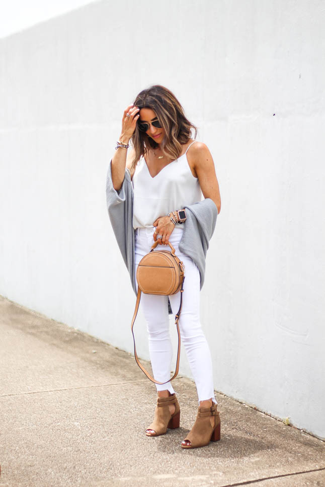 lifestyle and fashion blogger Alexis Belbel of A Double Dose wearing white jeans for petites, a white silk cami, grey shawl/cardigan, suede peep toe booties and a tan crossbody round bag from sole society