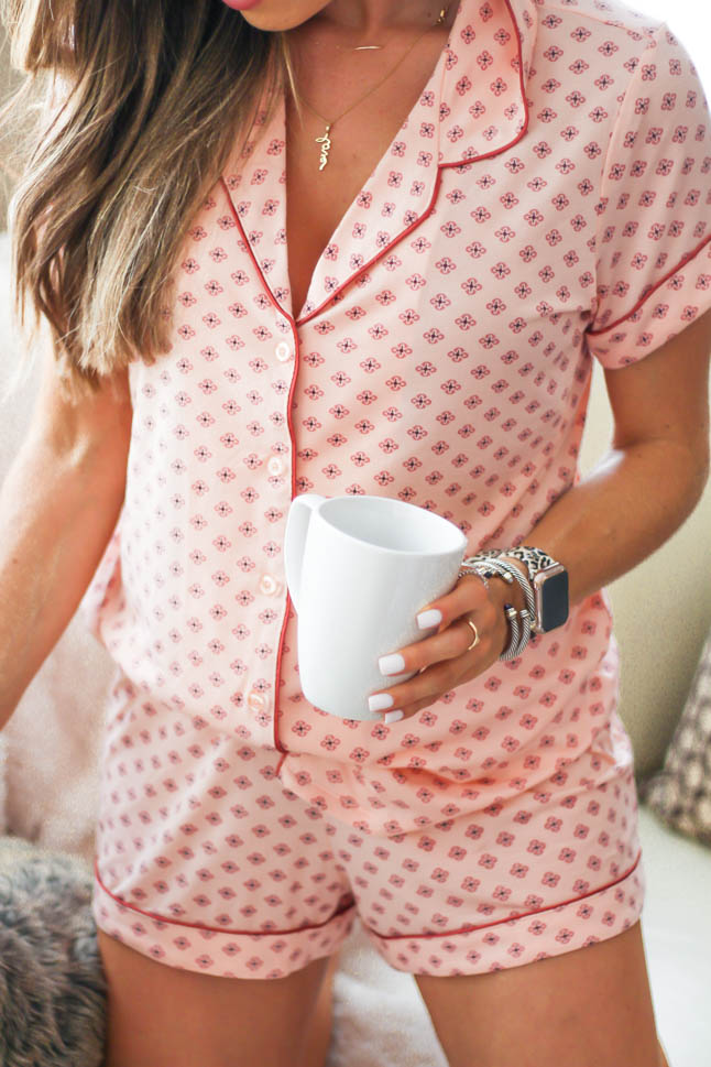 Lifestyle and fashion blogger samantha belbel of a double dose wearing pink printed short pajama set from Nordstrom with a cozy furry throw blanket barefoot dreams