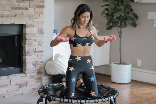 lifestyle and fashion blogger alexis belbel of a double dose shares her rebounder workout and the benefits of doing a rebounder workout with a Jumpsport trampoline. Wearing a star print workout legging set from Goldsheep.