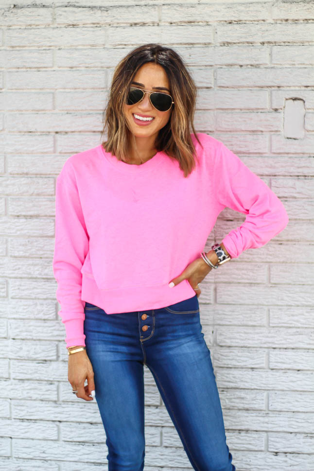 fashion and lifestyle blogger alexis belbel of adouble dose wearing a neon pink cropped sweatshirt with skinny stretchy jeans and epsadrille wedges from walmart fashion we dress america