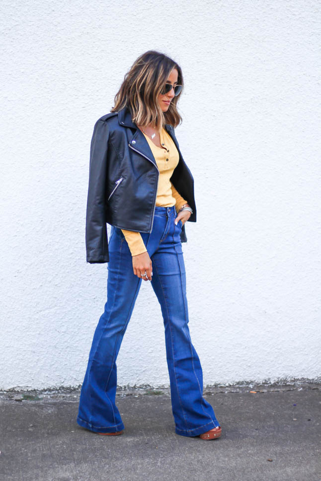 lifestlye and fashion blogger alexis belbel wearing a head to toe look from walmart we dress america. Wearing a faux leather moto jacket, yellow henley top with buttons, and high rise flare jeans for fall