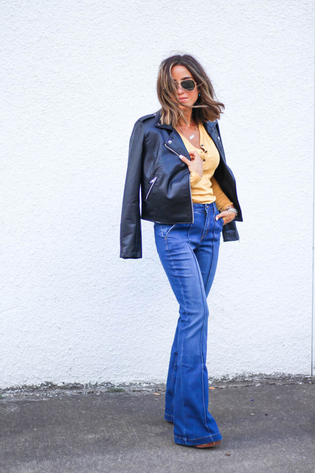 lifestlye and fashion blogger alexis belbel wearing a head to toe look from walmart we dress america. Wearing a faux leather moto jacket, yellow henley top with buttons, and high rise flare jeans for fall