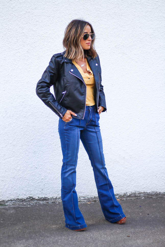 lifestlye and fashion blogger alexis belbel wearing a head to toe look from walmart we dress america. Wearing a faux leather moto jacket, yellow henley top with buttons, and high rise flare jeans for fall