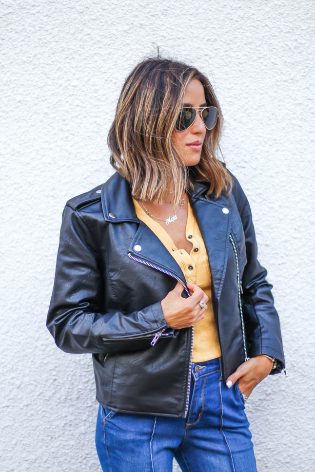 lifestlye and fashion blogger alexis belbel wearing a head to toe look from walmart we dress america. Wearing a faux leather moto jacket, yellow henley top with buttons, and high rise flare jeans for fall
