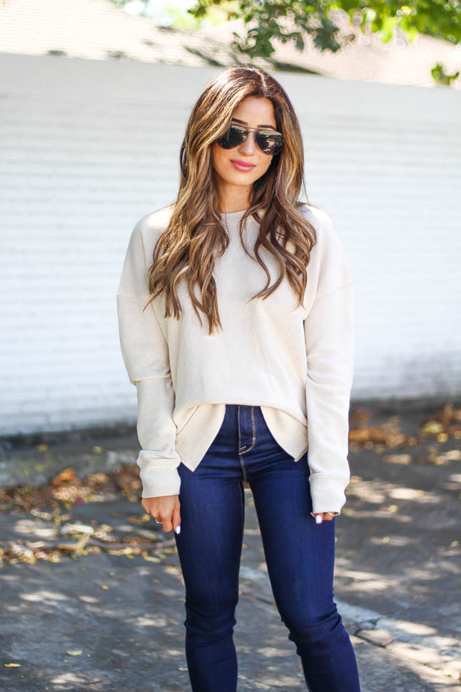 Fashion and lifestyle blogger samantha belbel wearing a cozy neutral sweatshirt and dark jeans from walmart with black van slip ons for fall 