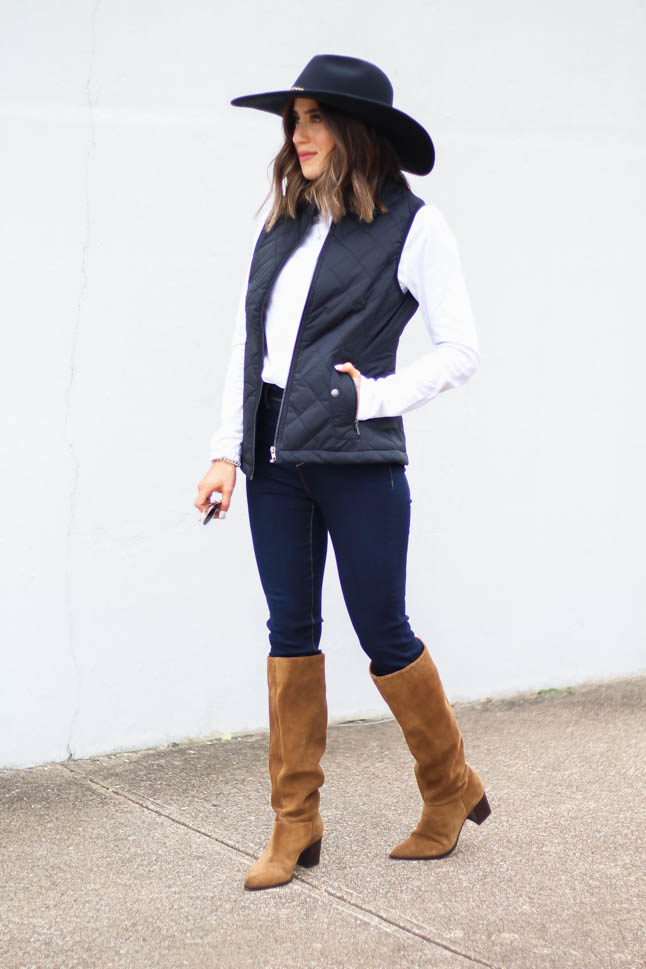lifestyle and fashion blogger, alexis belbel, of a double dose wearing a head-to-toe look from walmart. Black quilted vest, white long sleeve tee, dark skinny legging jeans, suede boots, and black wool hat