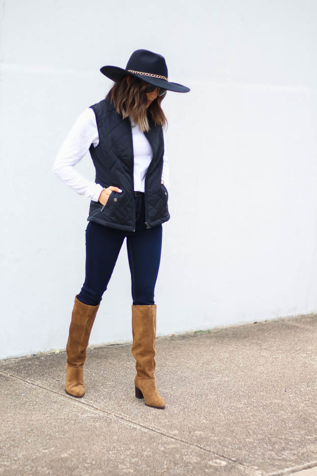 lifestyle and fashion blogger, alexis belbel, of a double dose wearing a head-to-toe look from walmart. Black quilted vest, white long sleeve tee, dark skinny legging jeans, suede boots, and black wool hat