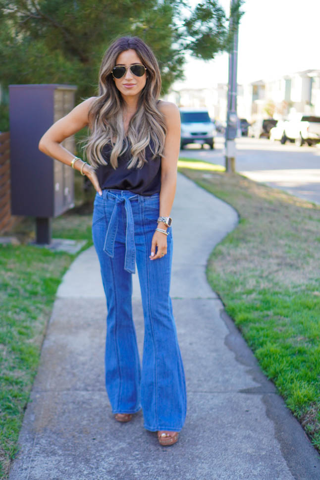 lifestyle and fashion blogger samantha belbel wearing flare jeans and a black lace cami with wedges from Express sharing what is in vs out in fashion spring 2020 trends | adoubledose.com