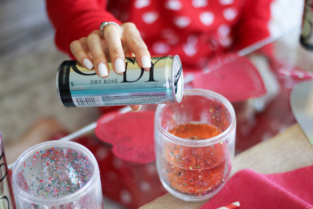 lifestyle and fashion blogger alexis and samantha belbel sharing their tips for hosting the perfect galentine's day with JaM cellars rose wine wearing red heart pajamas and festive valentines day decor| adoubledose.com
