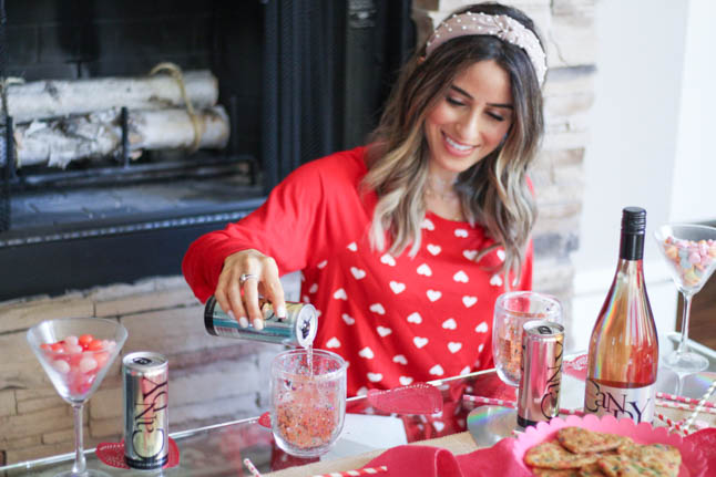 lifestyle and fashion blogger alexis and samantha belbel sharing their tips for hosting the perfect galentine's day with JaM cellars rose wine wearing red heart pajamas and festive valentines day decor| adoubledose.com