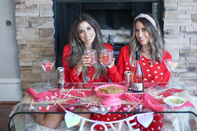 lifestyle and fashion blogger alexis and samantha belbel sharing their tips for hosting the perfect galentine's day with JaM cellars rose wine wearing red heart pajamas and festive valentines day decor| adoubledose.com