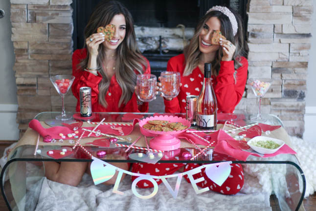 lifestyle and fashion blogger alexis and samantha belbel sharing their tips for hosting the perfect galentine's day with JaM cellars rose wine wearing red heart pajamas and festive valentines day decor| adoubledose.com