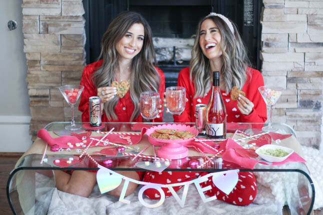 lifestyle and fashion blogger alexis and samantha belbel sharing their tips for hosting the perfect galentine's day with JaM cellars rose wine wearing red heart pajamas and festive valentines day decor| adoubledose.com