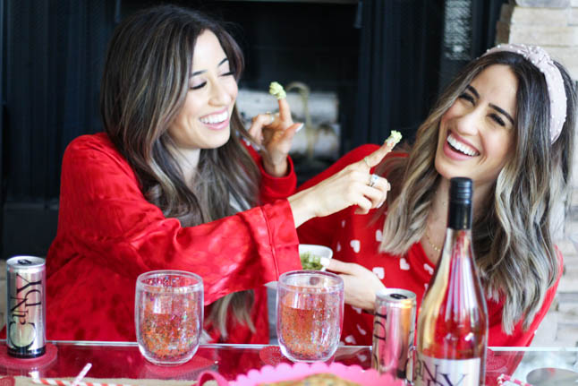 lifestyle and fashion blogger alexis and samantha belbel sharing their tips for hosting the perfect galentine's day with JaM cellars rose wine wearing red heart pajamas and festive valentines day decor| adoubledose.com