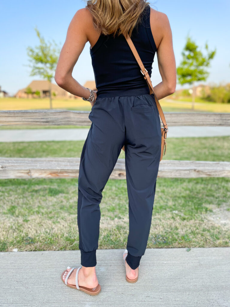 lifestyle and fashion blogger alexis belbel shares a few ways to style woven drawstring joggers from Zella at Nordstrom. Wearing with a black ribbed tank and denim jacket and slide sandals | adoubledose.com